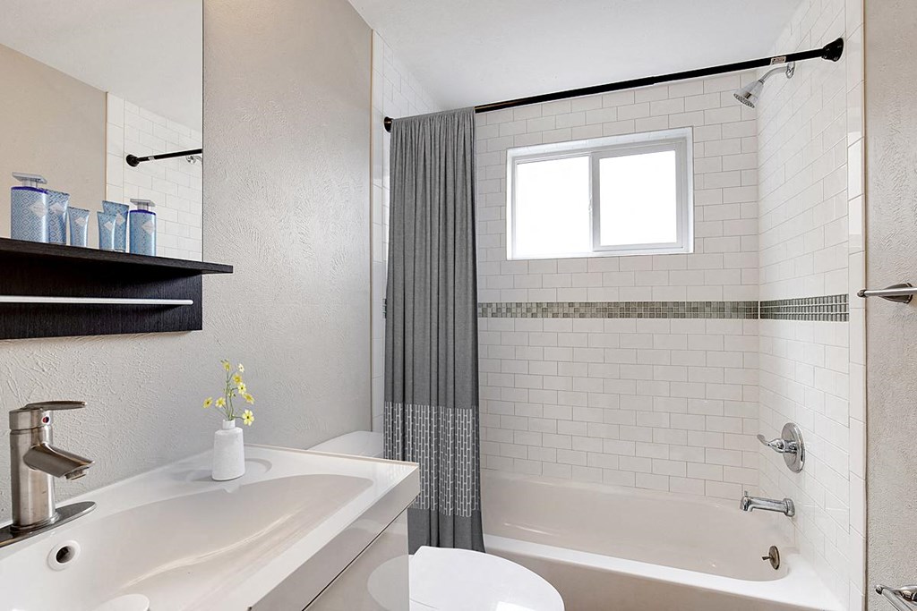 a white bathroom with a tub and a sink