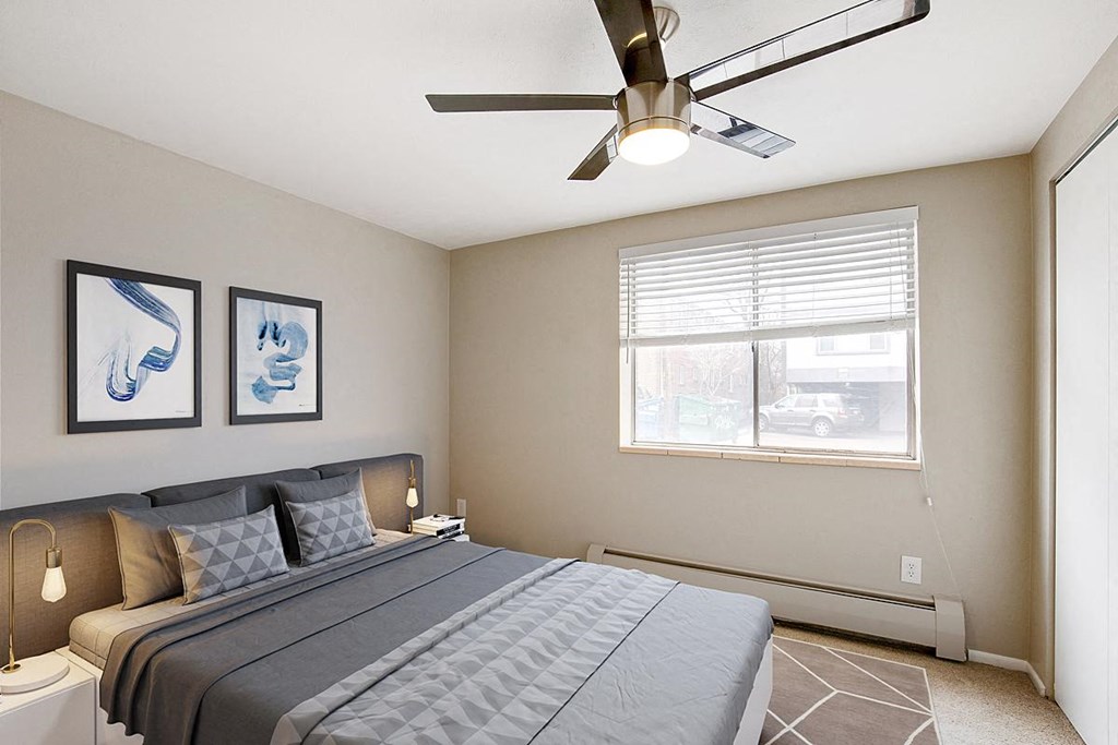 a bedroom with a large bed and a ceiling fan