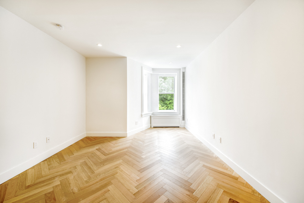 a living room with a hard wood floor and a window
