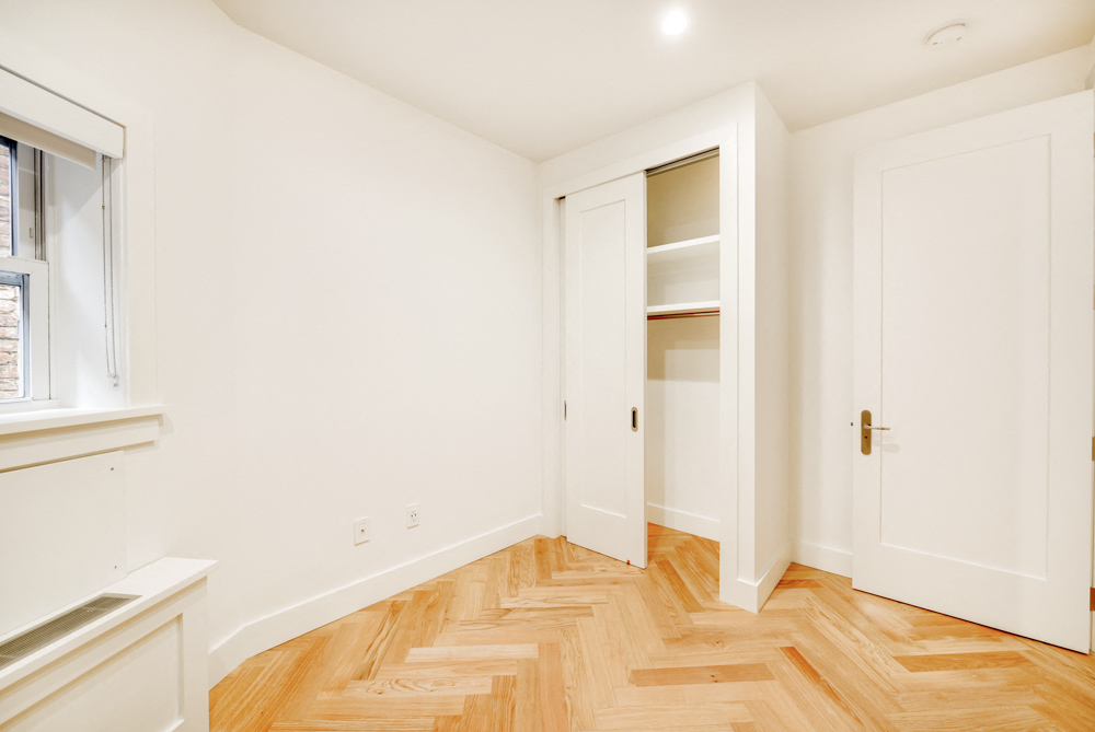 a living room with wood flooring and a door to a closet