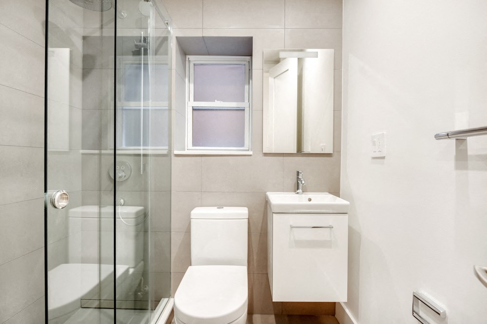 a bathroom with a toilet and a sink and a shower