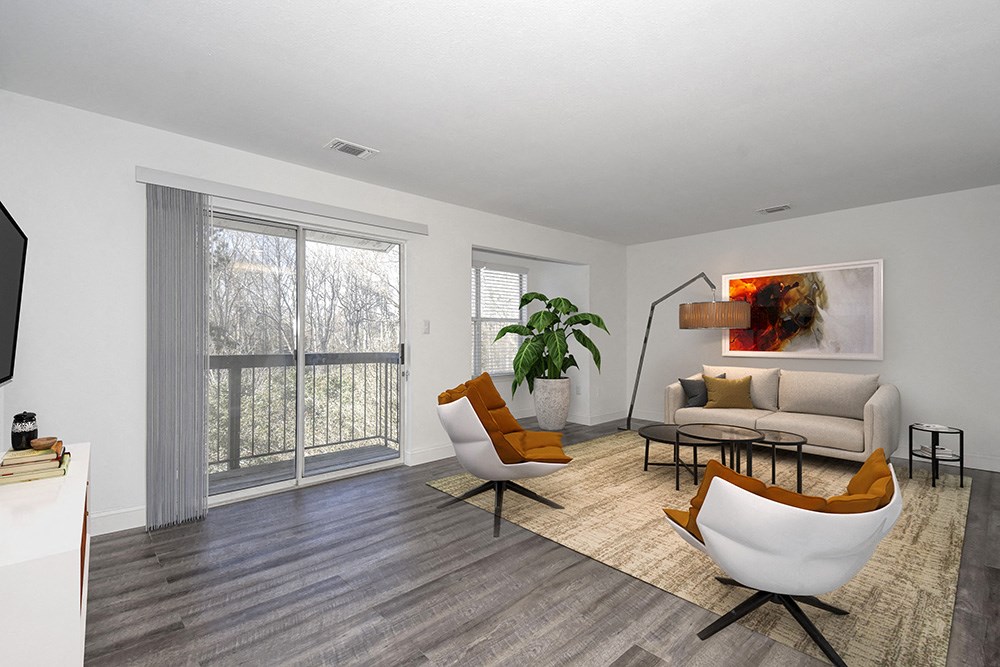 a living room with a large window and a couch and chairs