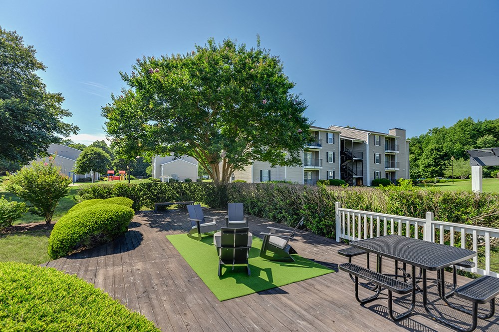 an outdoor patio with tables and chairs and a tree