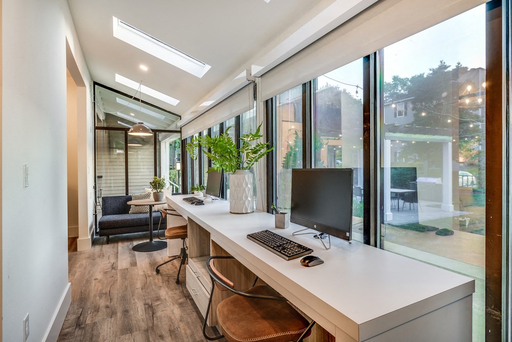 a home office with a large window and a computer on a desk