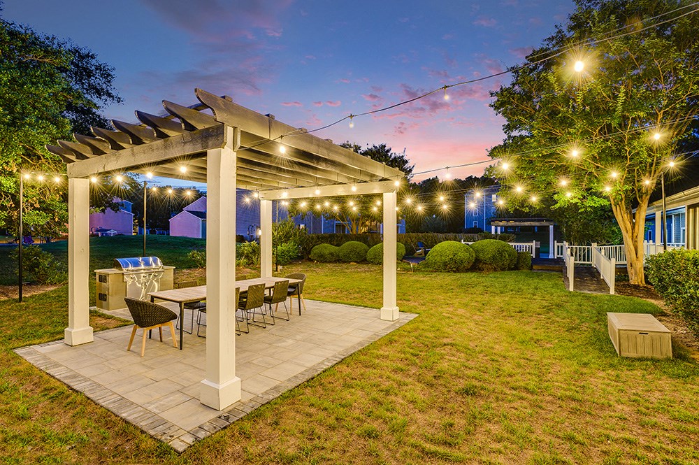 a backyard with a pergola and a table and chairs