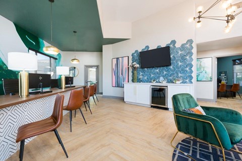 A modern living room with a green chair and a television on the wall.