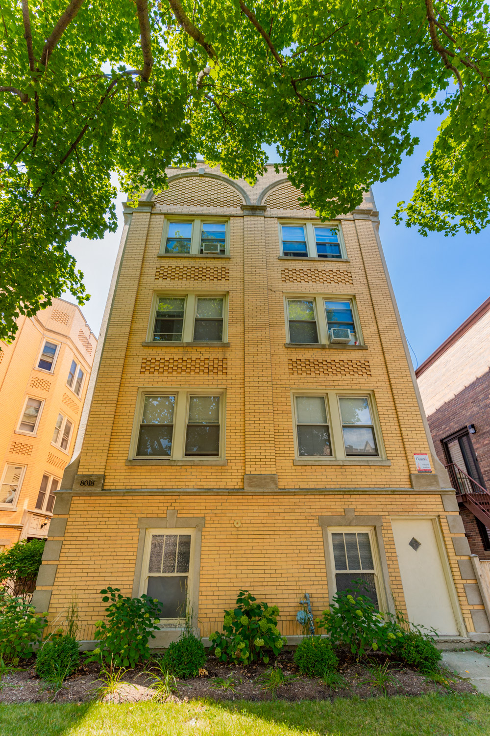 a tall brick building with some trees in front of it