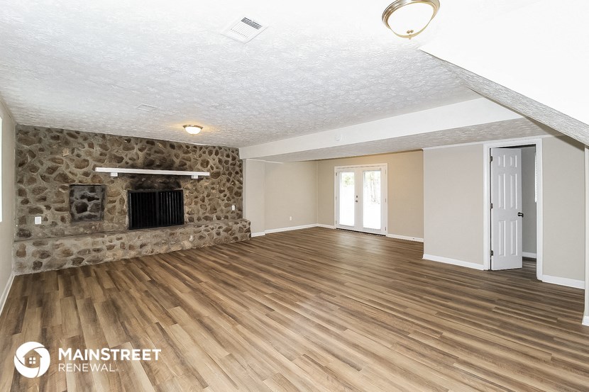 the living room has a fireplace and hardwood floors