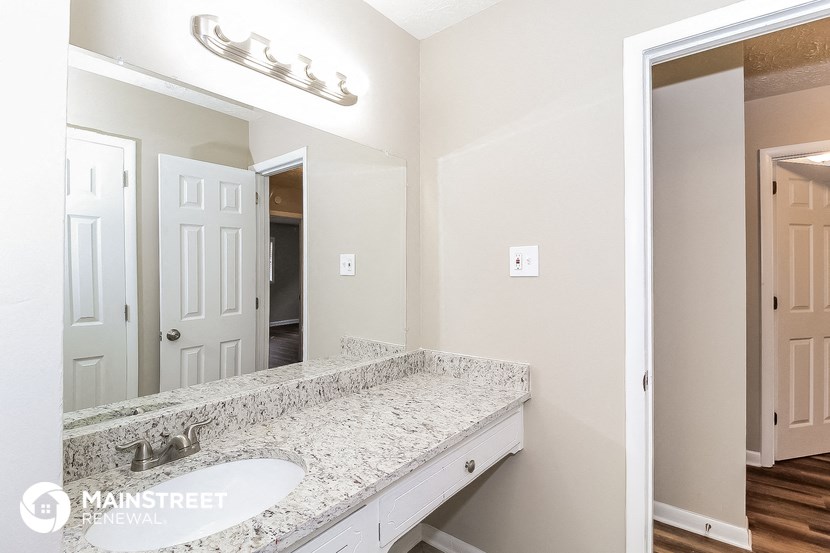 the master bathroom has a large mirror and a large sink