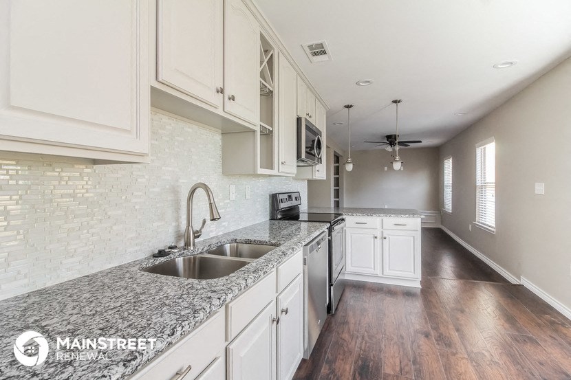 a kitchen with marble counter tops and white cabinets