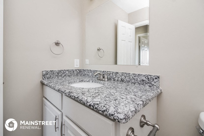 a bathroom with a marble counter top and a sink