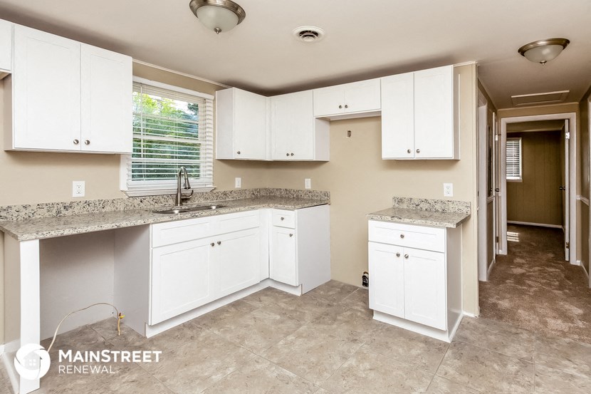 a kitchen with white cabinets and granite counter tops