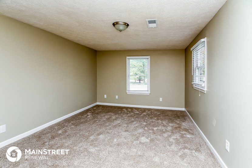 an empty room with carpet and a window