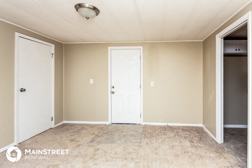 a master bedroom with a door to the closet and a hallway with a closet door