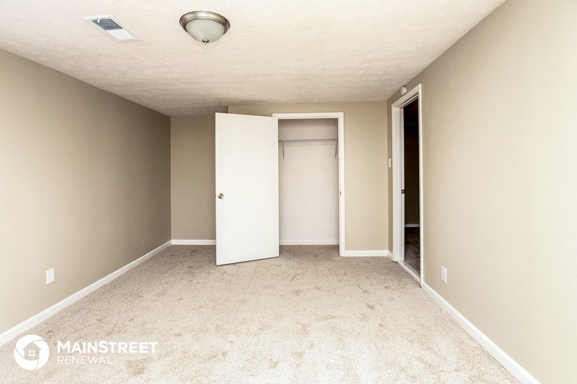 an empty room with a closet and a door to the bathroom