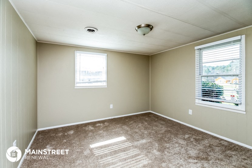an empty room with carpet and a window