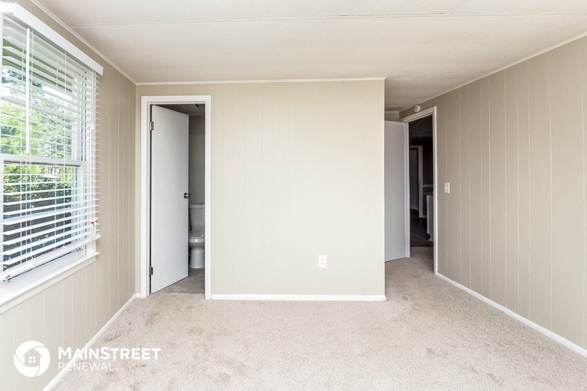 a bedroom with a carpeted floor and a door to a closet