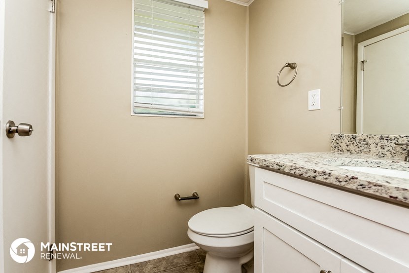 a bathroom with a toilet and a sink and a mirror