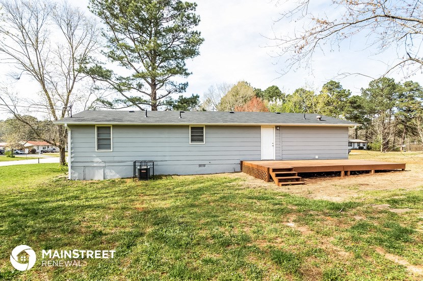 a small blue house with a wooden deck in the yard