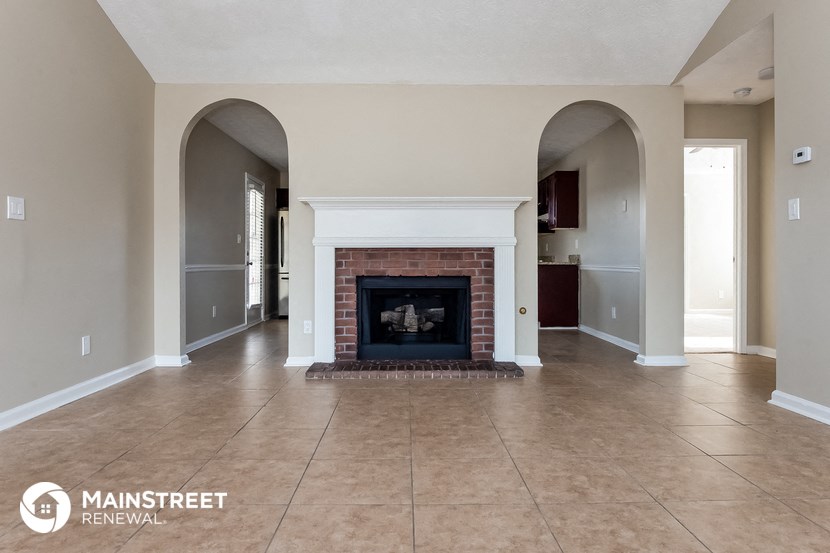 a living room with a fireplace and a tile floor
