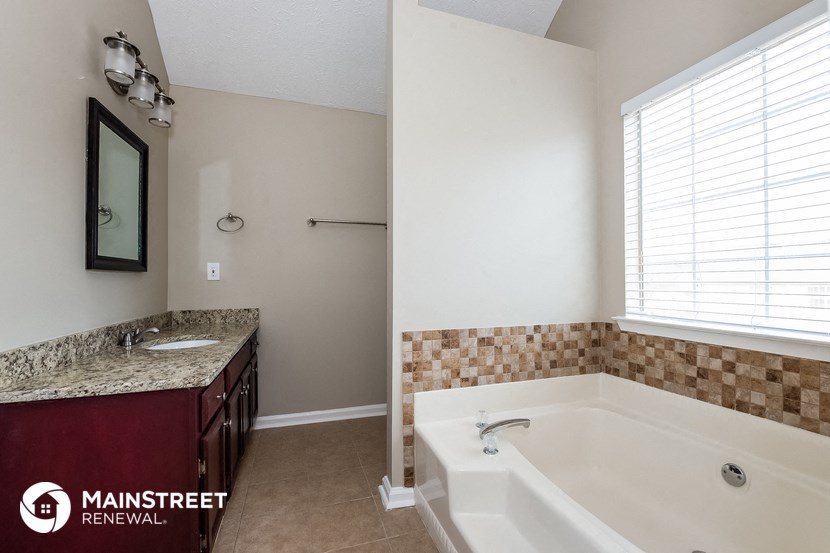 a bathroom with a tub and a sink and a mirror