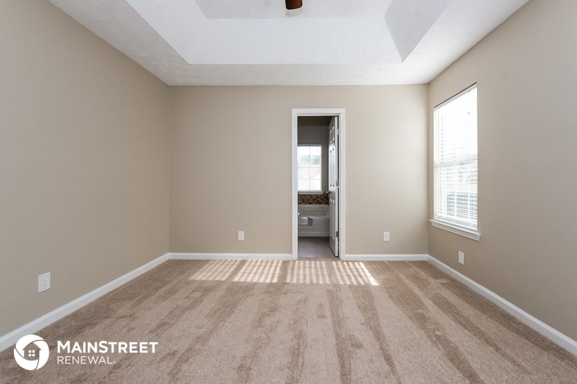 an empty living room with carpet and a large window