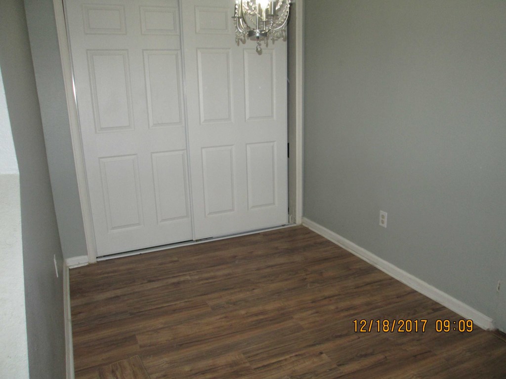 a room with a white door and wood flooring