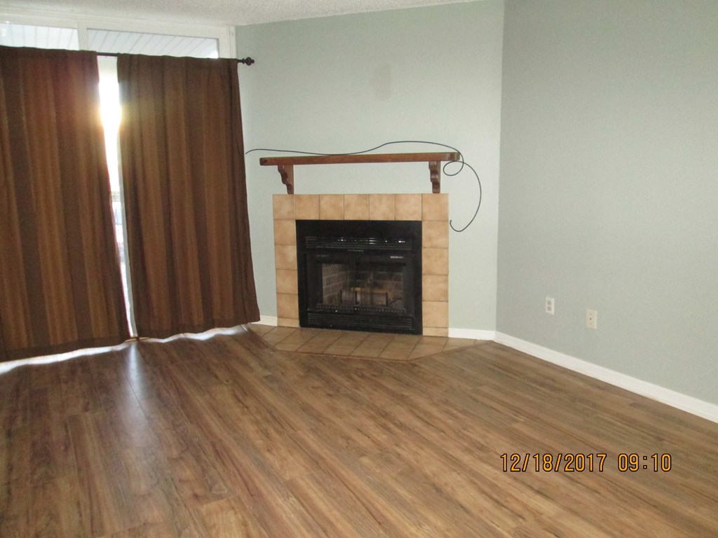a living room with wood floors and a fireplace