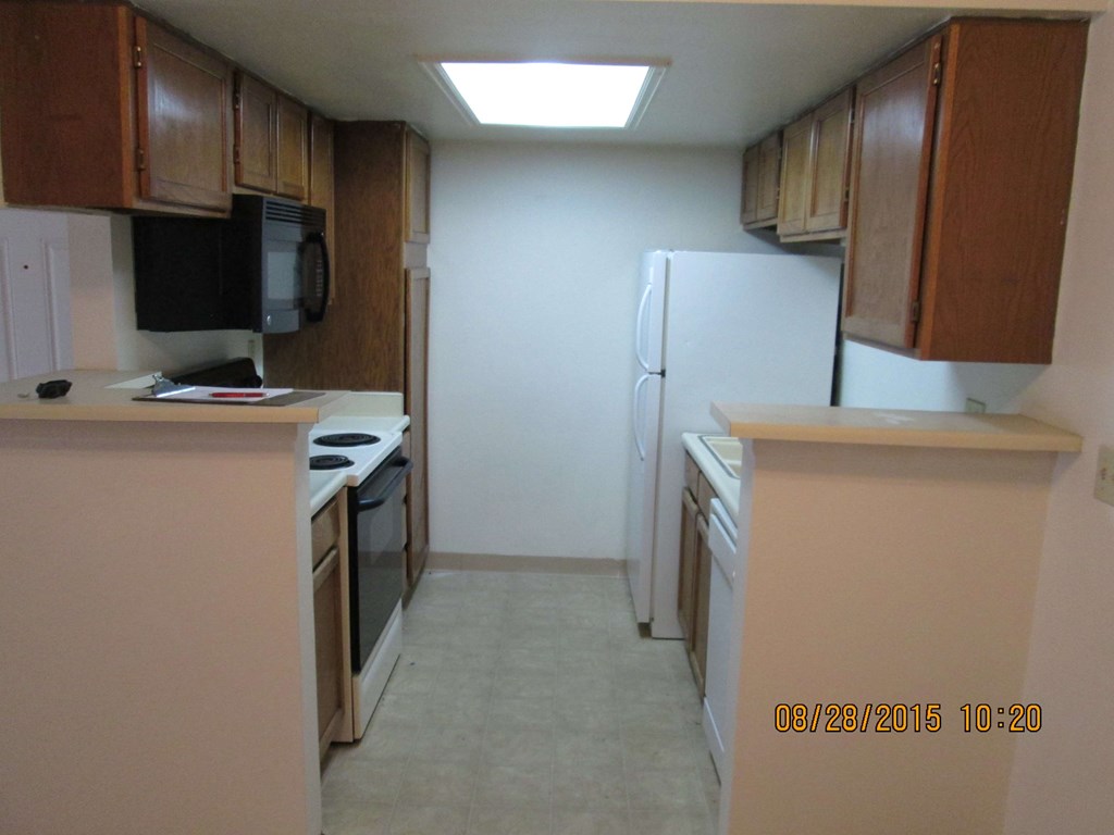 a kitchen with white appliances and wooden cabinets
