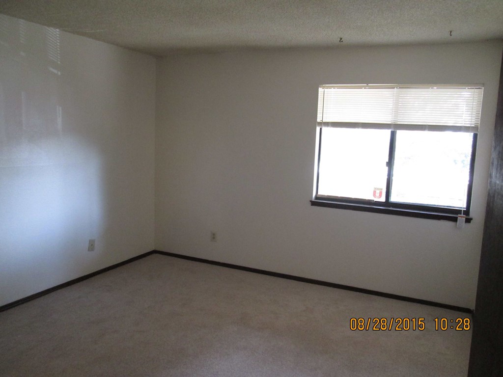 a bedroom with a window and white walls