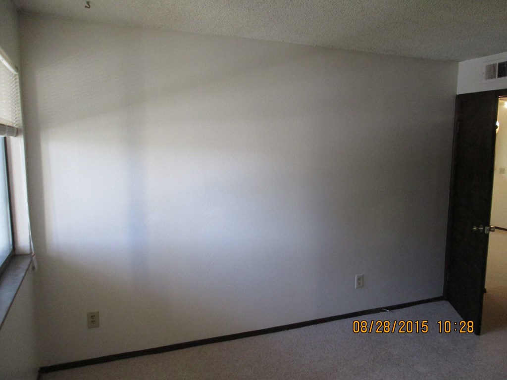 an empty room with white walls and a door