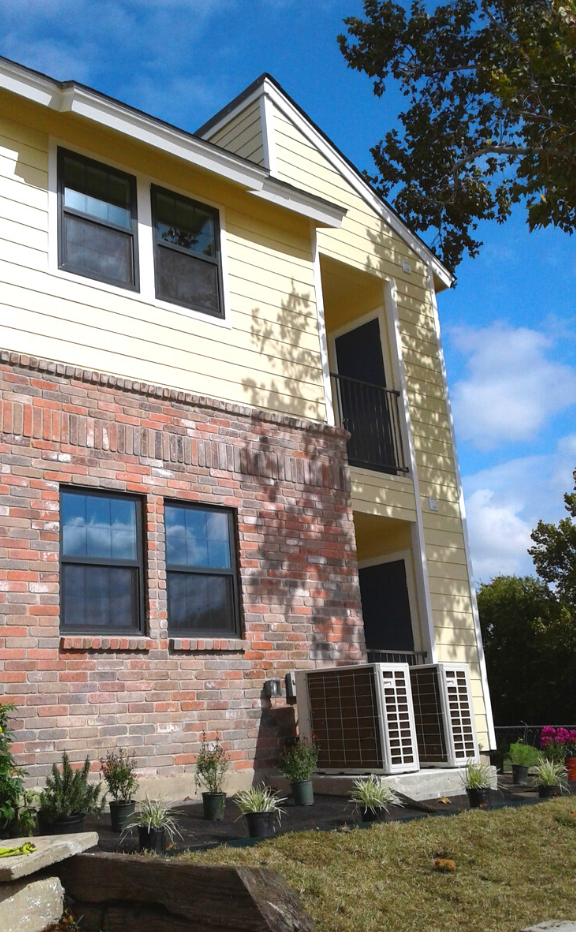the front of a brick house with a yellow and white building