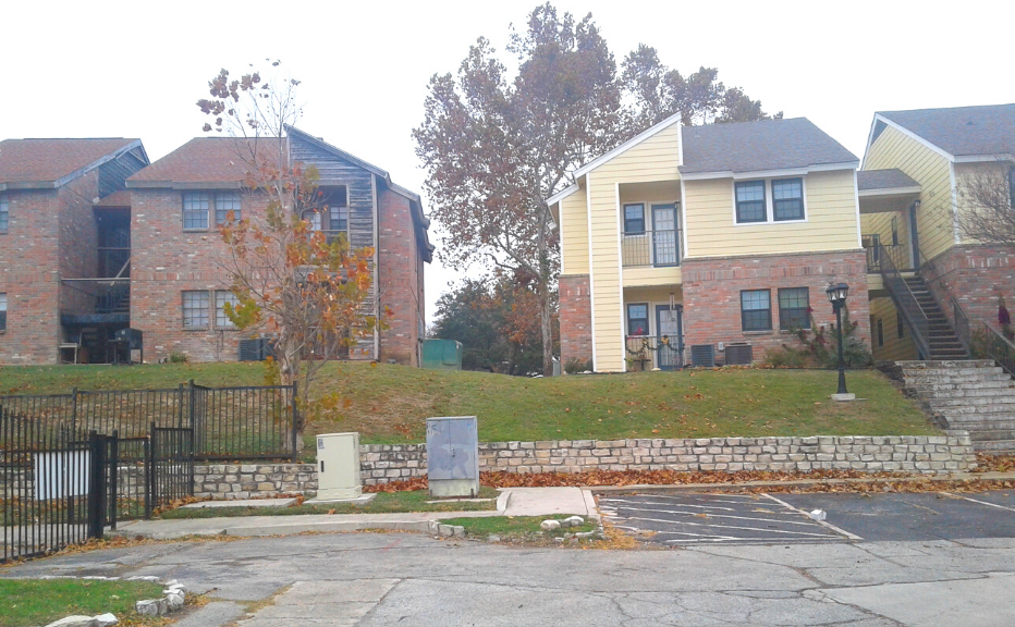 an empty parking lot in front of two houses