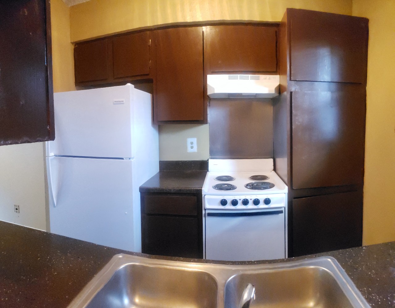 a kitchen with a stove refrigerator and a sink