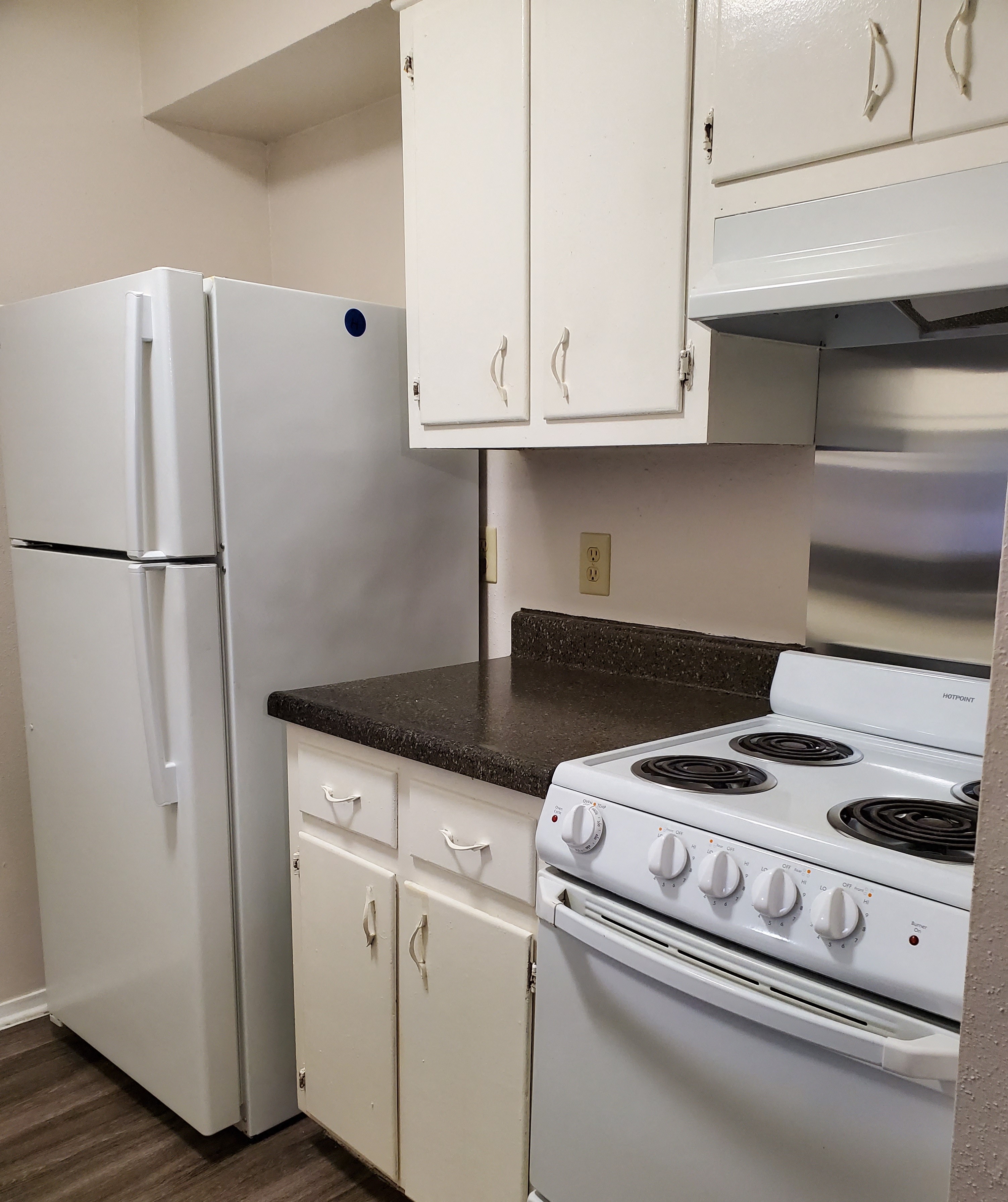 a kitchen with white appliances and white cabinets and a refrigerator