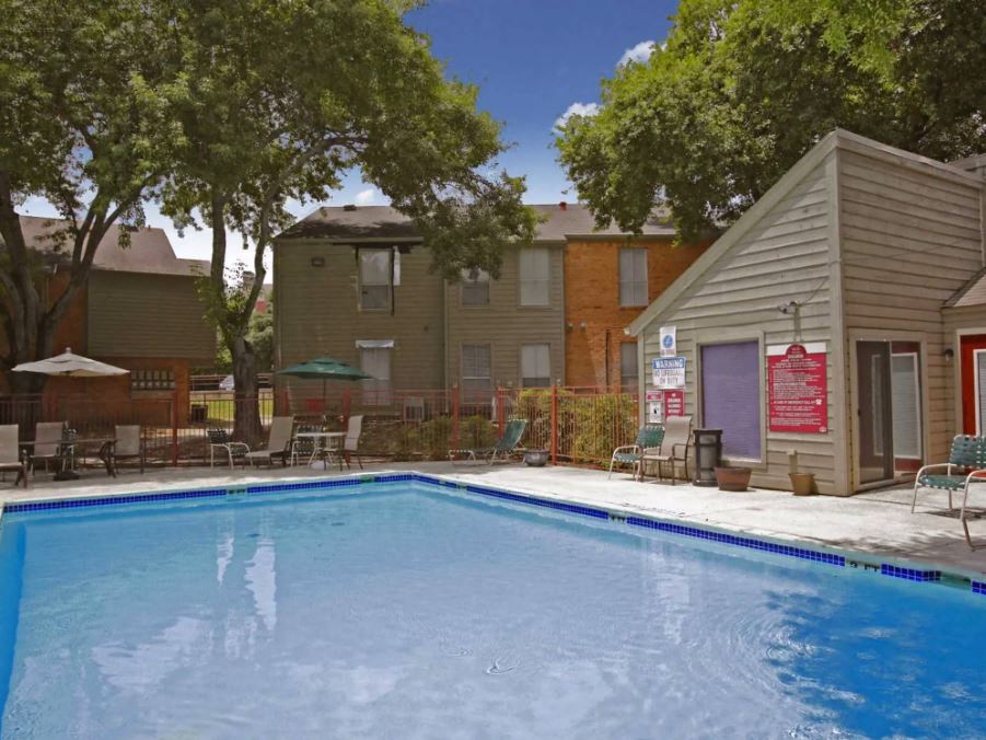 Big clear blue pool with seating and umbrellas