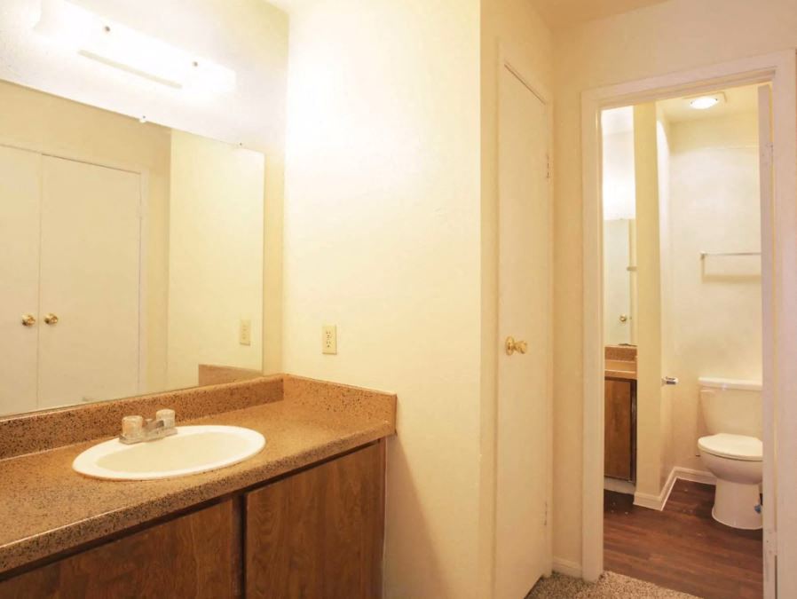 Bathroom sink and mirror and view of entry way to bathroom