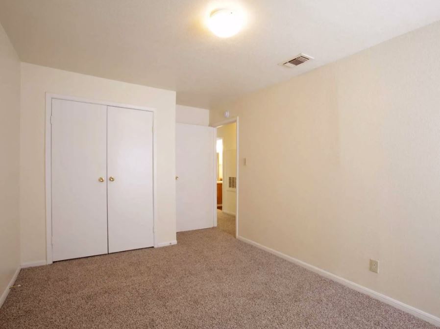 Bedroom view  with sandy colored carpets and eggshell white walls