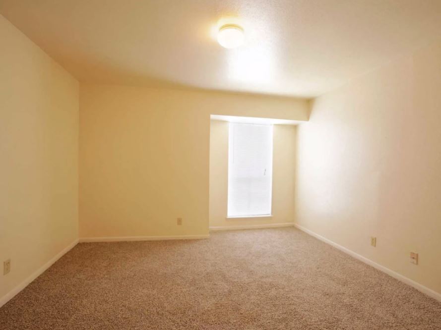 Bedroom view  with sandy colored carpets and eggshell white walls