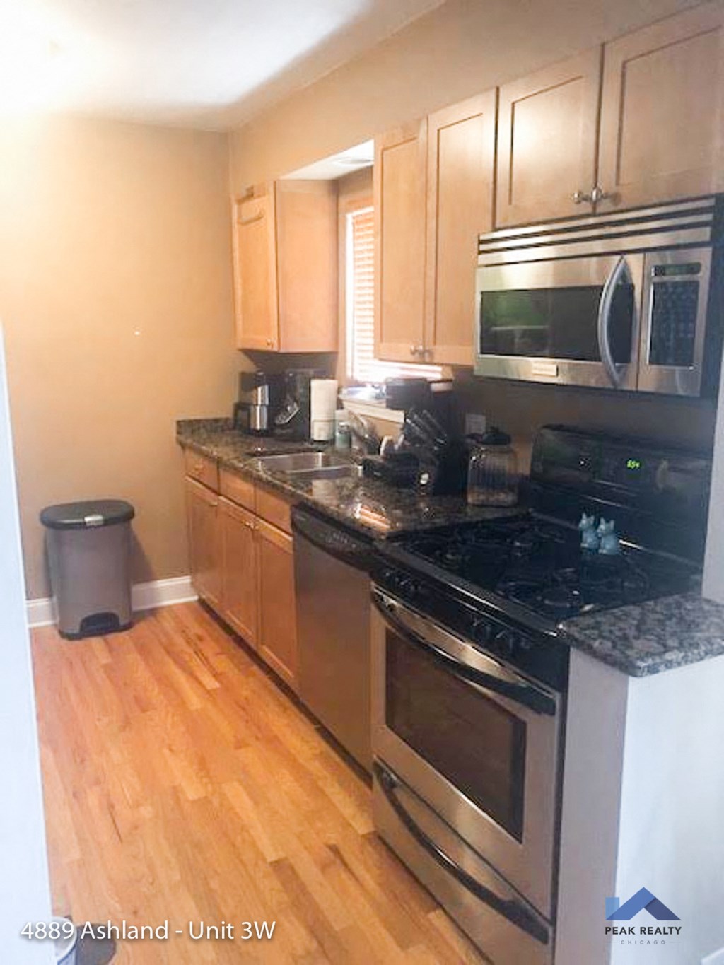 a kitchen with stainless steel appliances and wooden floors