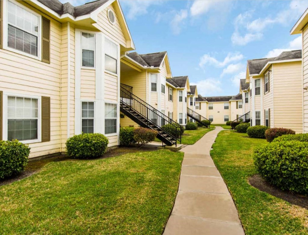 a row of houses with a sidewalk in front of them