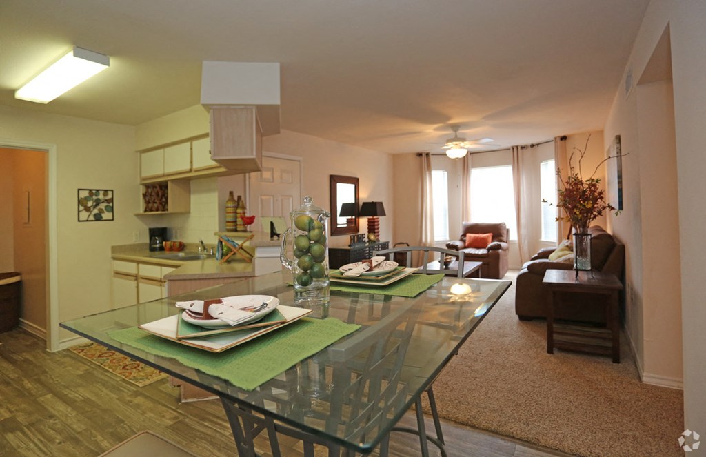 a living room and dining room with a glass table