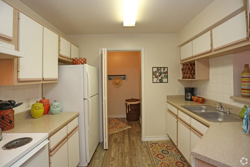 a kitchen with white cabinets and a sink and a refrigerator