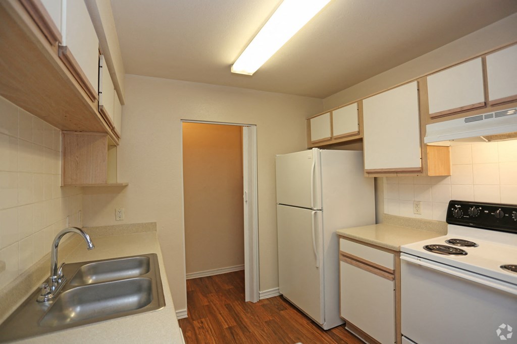 a kitchen with a sink and a stove and a refrigerator