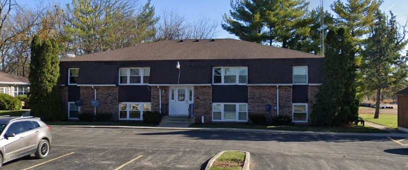 a brick house with a car parked in front of it