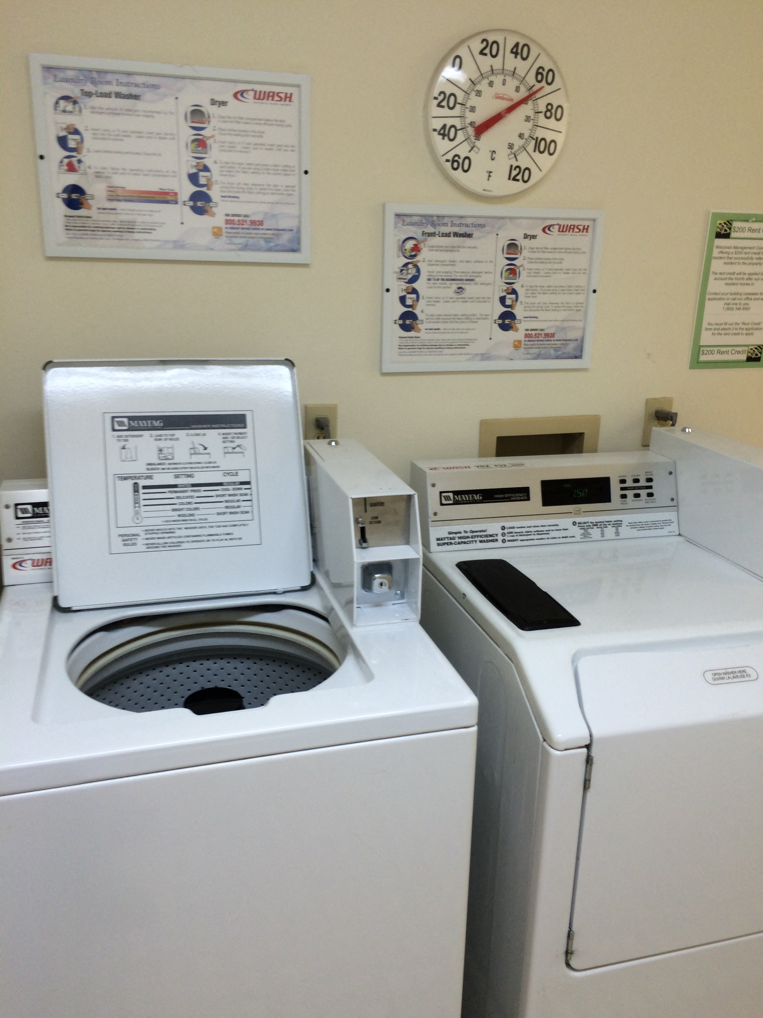 a laundry room with two washing machines and a clock on the wall
