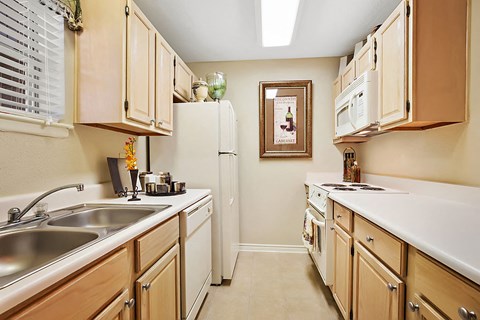 A kitchen with wooden cabinets and a white refrigerator.