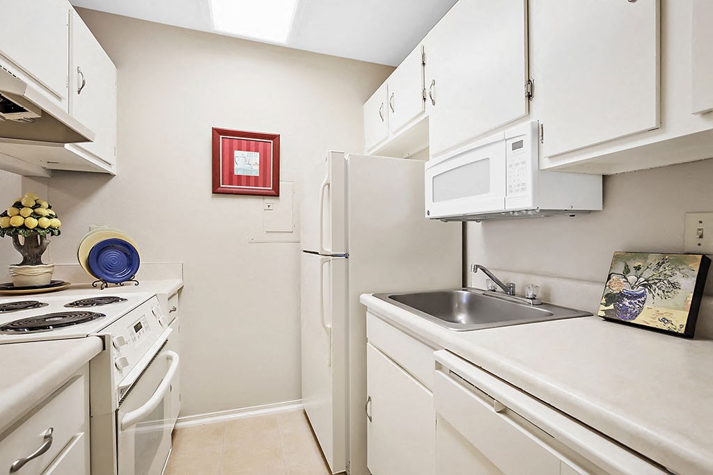 a kitchen with white appliances and a sink and a refrigerator