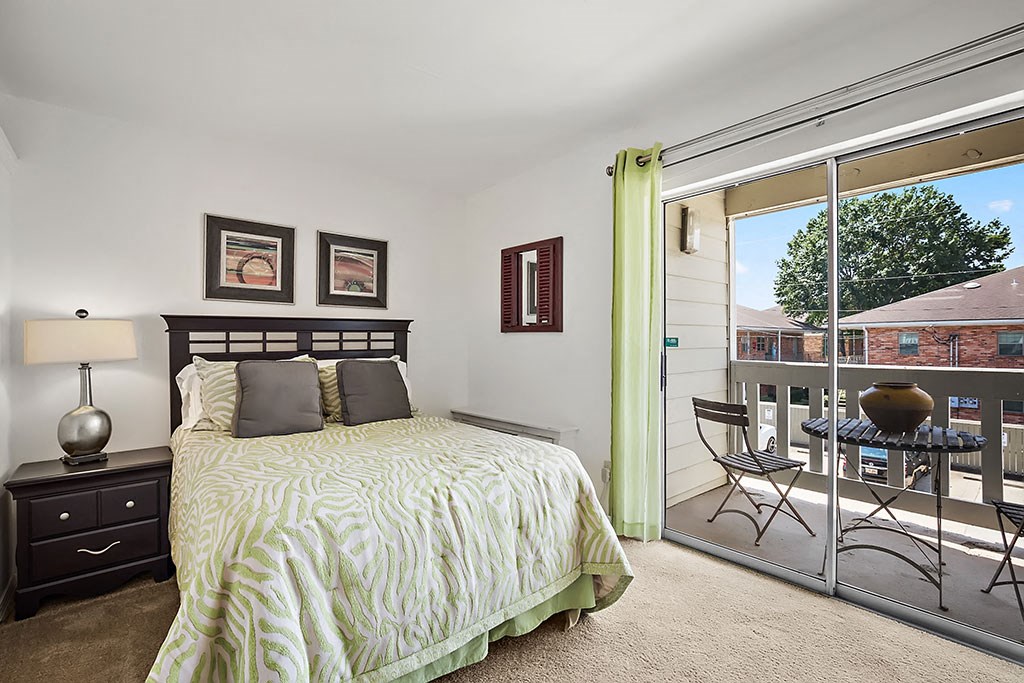 a bedroom with a bed and a sliding glass door