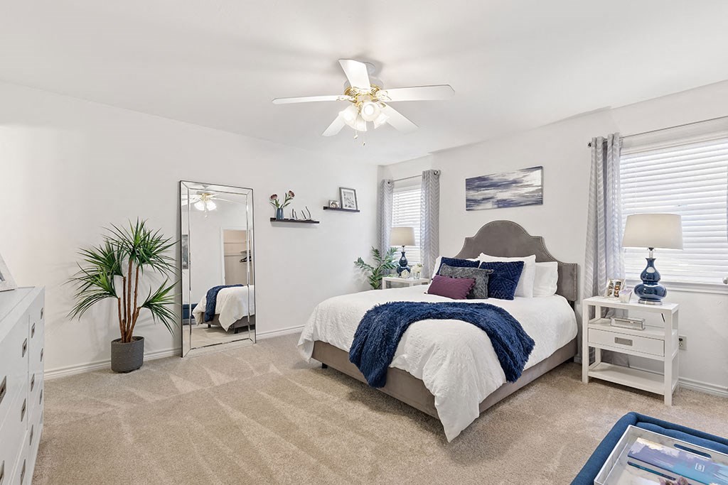 a bedroom with a bed and a ceiling fan